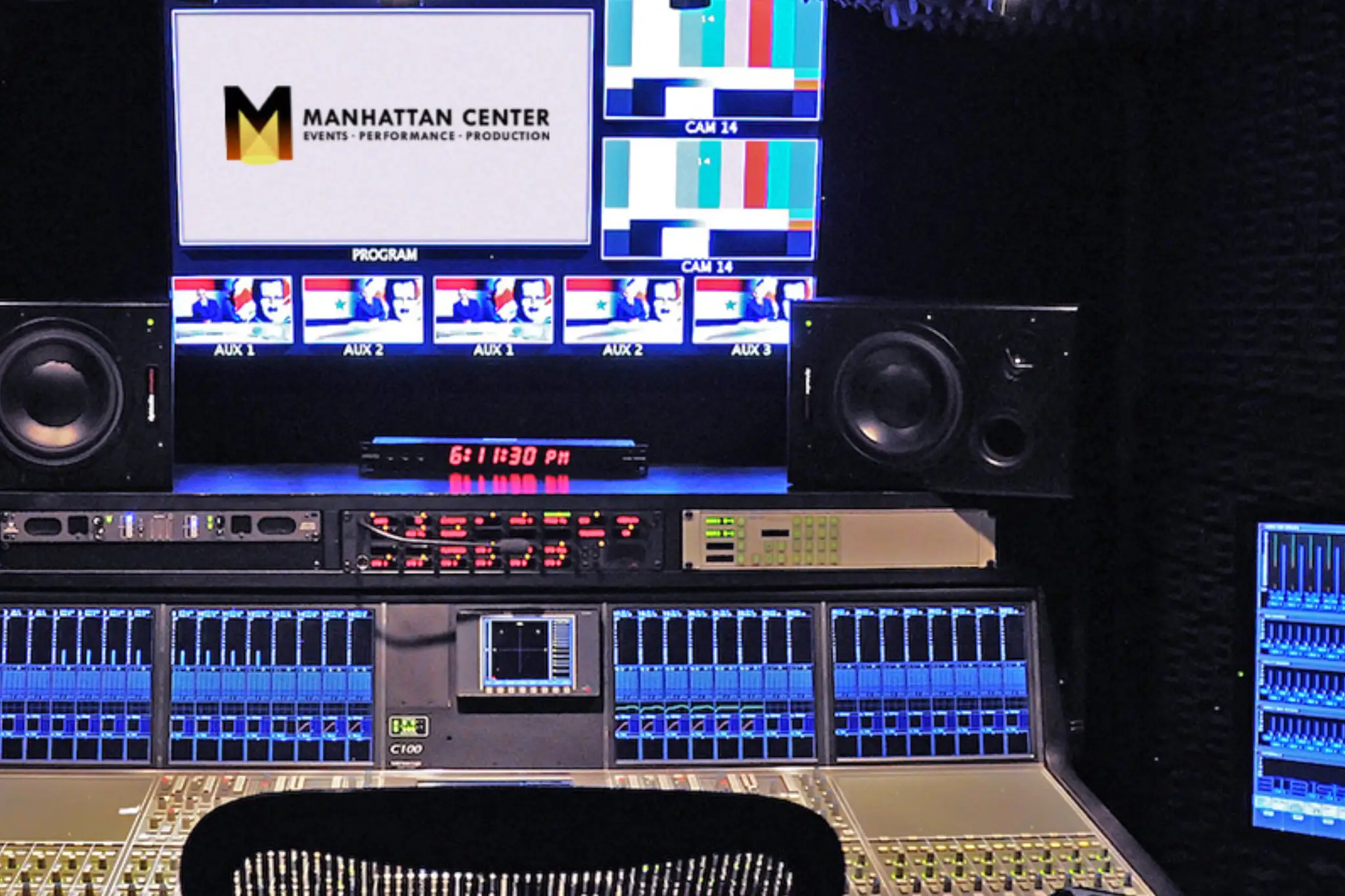 A modern audio-visual control room featuring monitors, sound equipment, and a mixing console, branded with the Manhattan Center logo A modern audio-visual control room featuring monitors, sound equipment, and a mixing console, branded with the Manhattan Center logo
